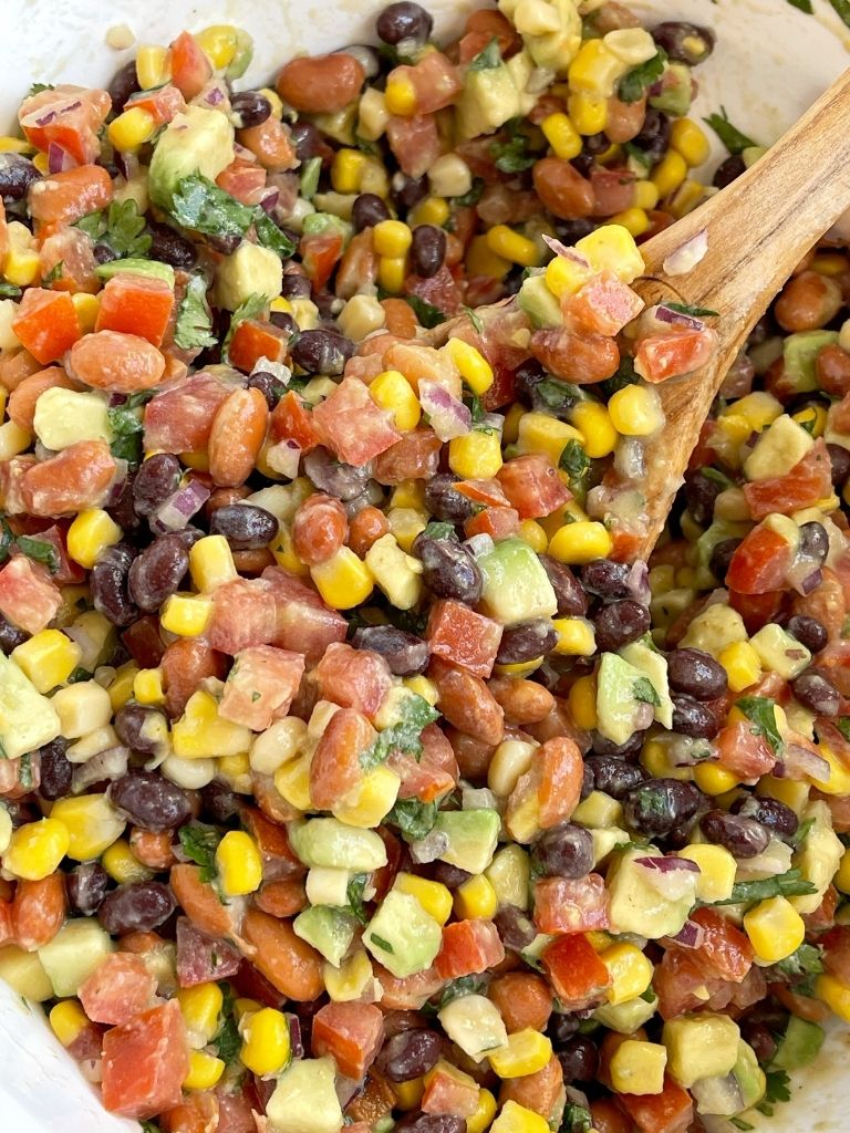 Cowboy salsa recipe inside a bowl with a wooden spoon