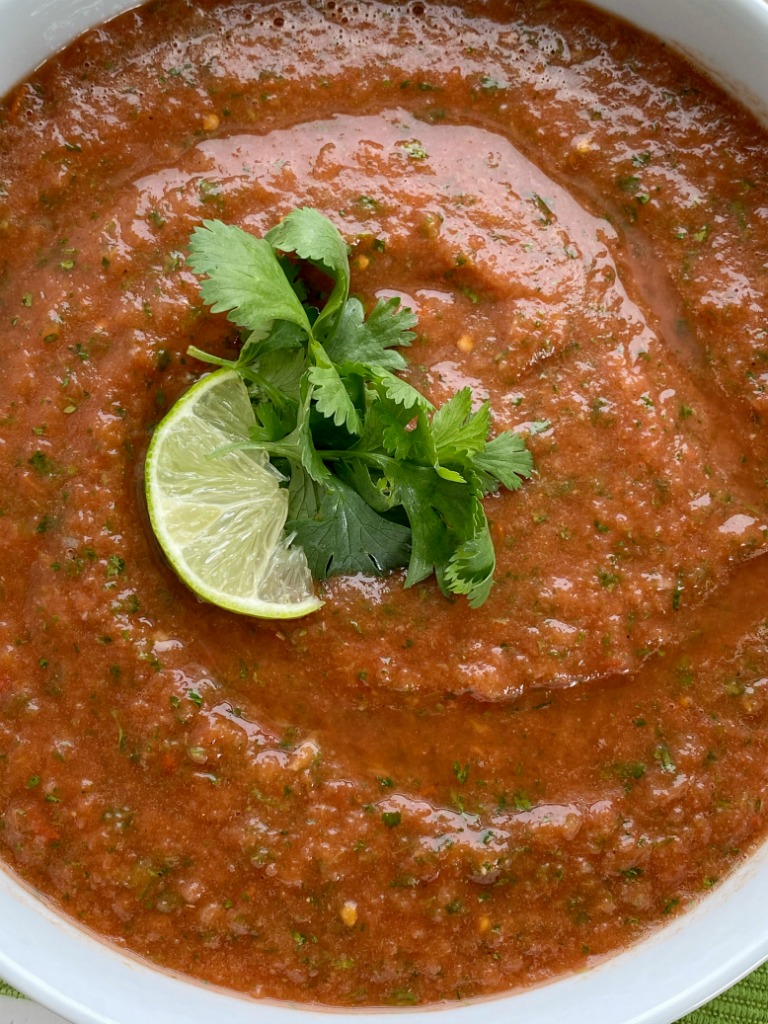 Homemade Salsa with canned whole tomatoes, stewed tomatoes, onion, garlic, jalapeno, cilantro, and seasonings. So simple to make, inexpensive, and it tastes better than anything you'll get at the restaurant or buy in the store. Mild enough for kids but can easily be made spicy!