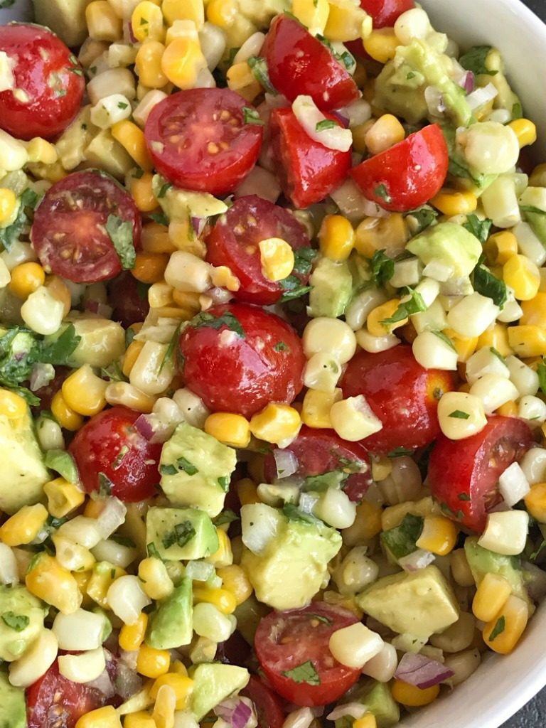 Avocado Corn Tomato Salad | Side Dish | Avocado | Healthy Recipe | Avocado Corn Tomato Salad is an easy, light, and refreshing salad! Chunks of avocado, sliced tomato and frozen corn are covered in an easy lime & olive oil dressing. Simple ingredients with amazing taste. Perfect for a light lunch, BBQ, potluck, or as a side for dinner. #healthy #salad #avocado #sidedish