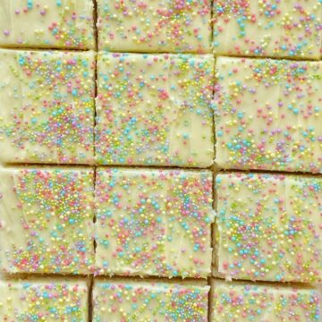 Sugar Cookie Bars made in a 9x13 pan that are soft, sweet and topped with the best (not too sweet) frosting and sprinkles! Change up the frosting color and sprinkles for any occasion.