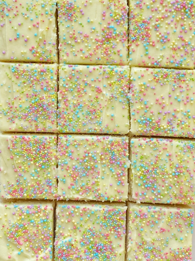 Sugar Cookie Bars made in a 9x13 pan that are soft, sweet and topped with the best (not too sweet) frosting and sprinkles! Change up the frosting color and sprinkles for any occasion. 