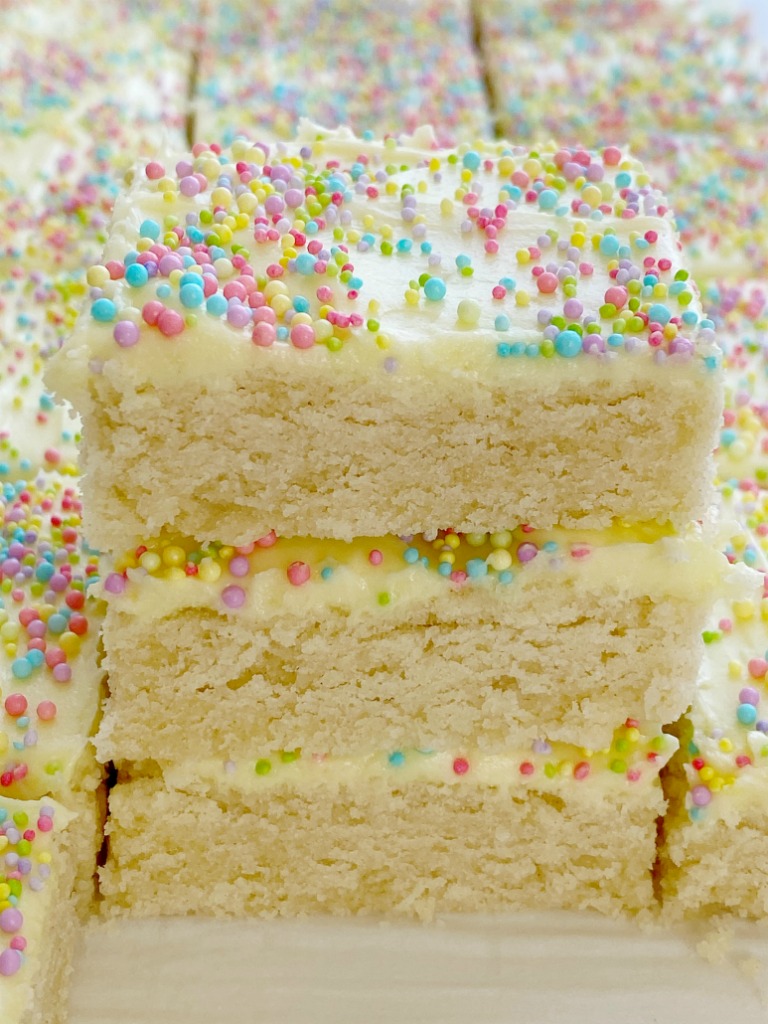 Sugar Cookie Bars made in a 9x13 pan that are soft, sweet and topped with the best (not too sweet) frosting and sprinkles! Change up the frosting color and sprinkles for any occasion. 