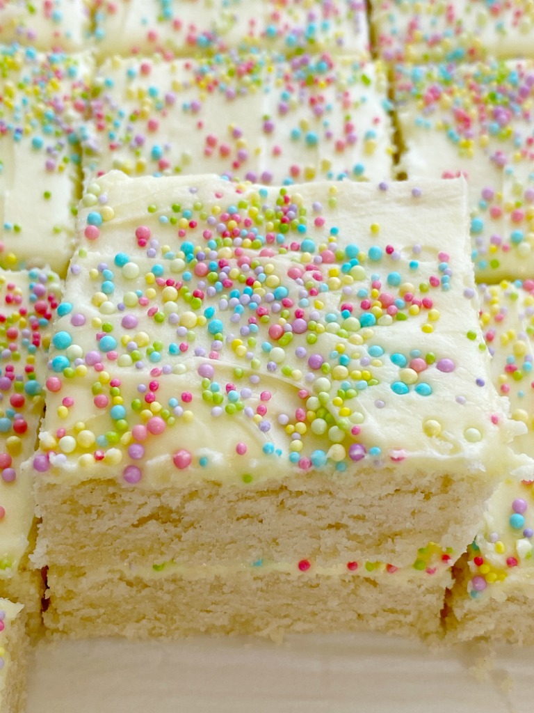 Sugar Cookie Bars made in a 9x13 pan that are soft, sweet and topped with the best (not too sweet) frosting and sprinkles! Change up the frosting color and sprinkles for any occasion. 