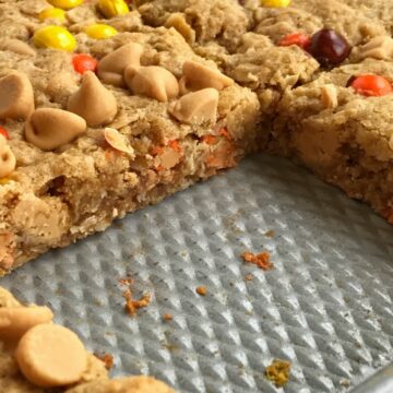 No flour triple peanut butter monster cookie bars are loaded with peanut butter, peanut butter chips, mini reese's pieces, and oatmeal! This recipe makes an entire cookie sheet of bars & they freeze perfectly. Perfect for lunchboxes or snacks for the week.