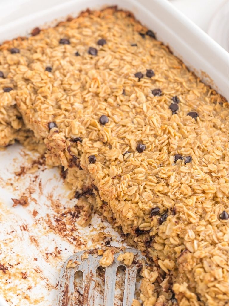 A pan of baked oatmeal with a stainless steel server inside the baking pan.