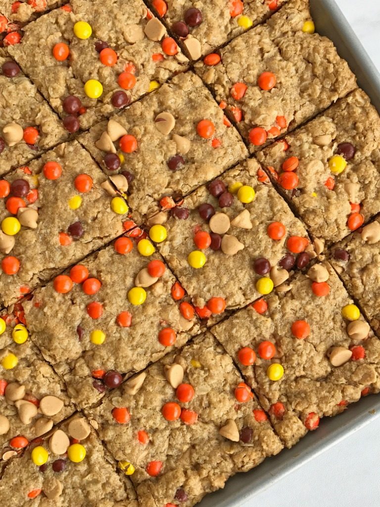 No flour triple peanut butter monster cookie bars are loaded with peanut butter, peanut butter chips, mini reese's pieces, and oatmeal! This recipe makes an entire cookie sheet of bars & they freeze perfectly. Perfect for lunchboxes or snacks for the week. 