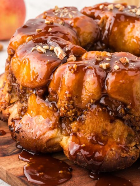 View of the monkey bread with butterscotch glaze on a wooden cutting board.