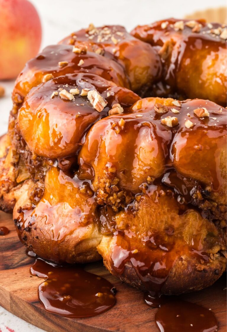 View of the monkey bread with butterscotch glaze on a wooden cutting board.