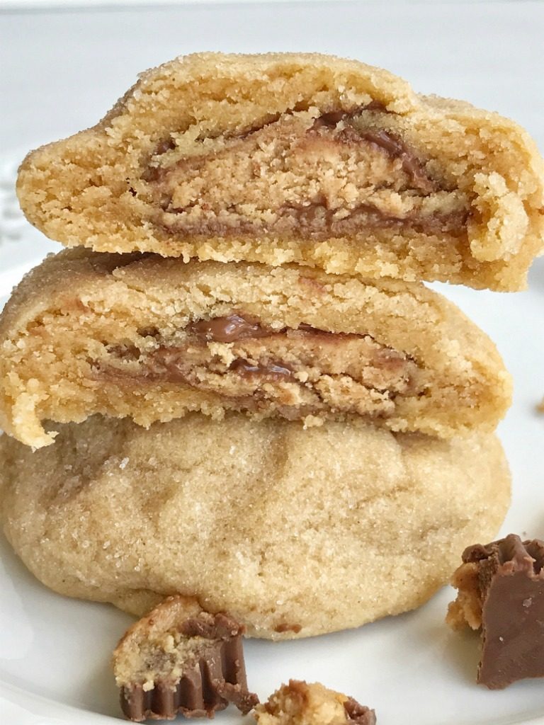 Thick & puffy peanut butter cookies stuffed with a surprise of a miniature Reese's peanut butter cup! These thick & soft baked peanut butter cookies are full of peanut butter flavor with a candy surprise in the middle.