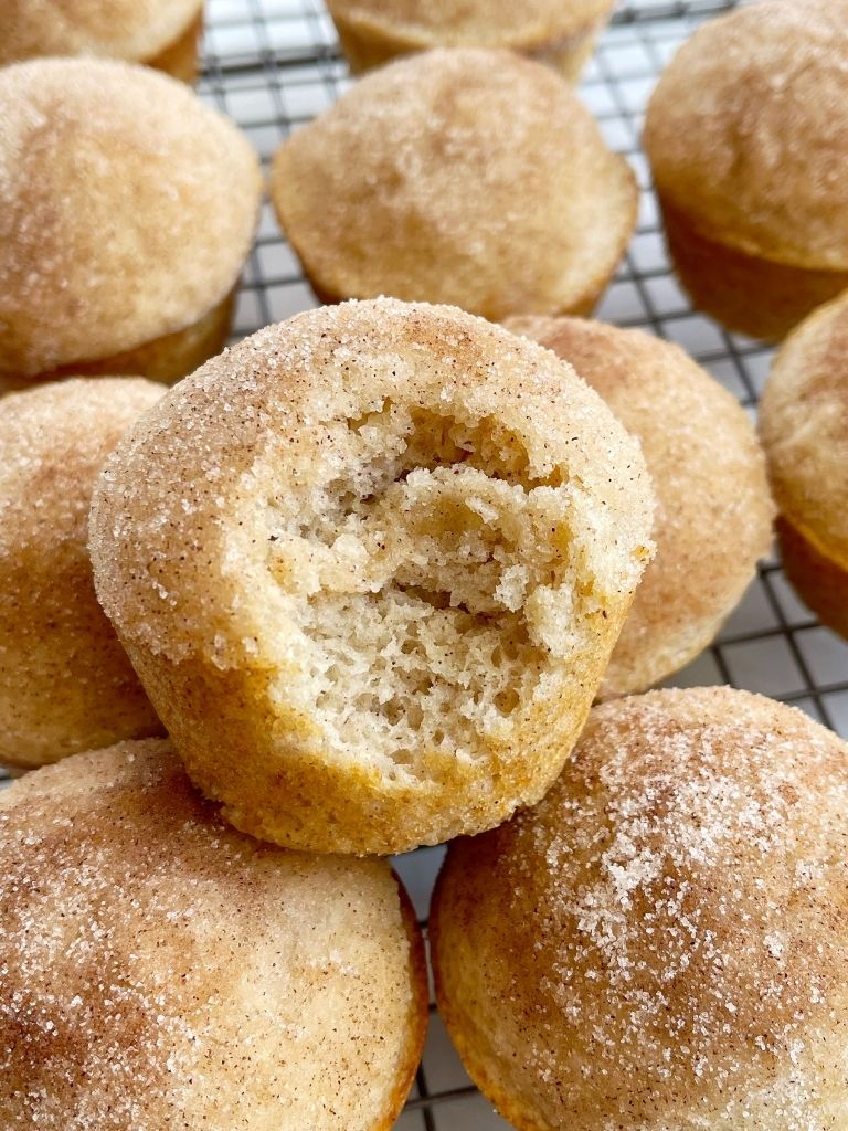 A cinnamon and sugar donut muffins with a bite taken out of it. 