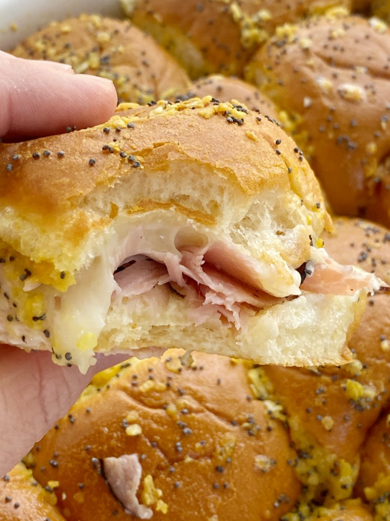 Baked Ham & Cheese Sandwiches are an easy family favorite dinner. Sweet Hawaiian rolls, deli sliced honey ham, shredded swiss cheese slathered in a delicious seasoned buttery sauce. 