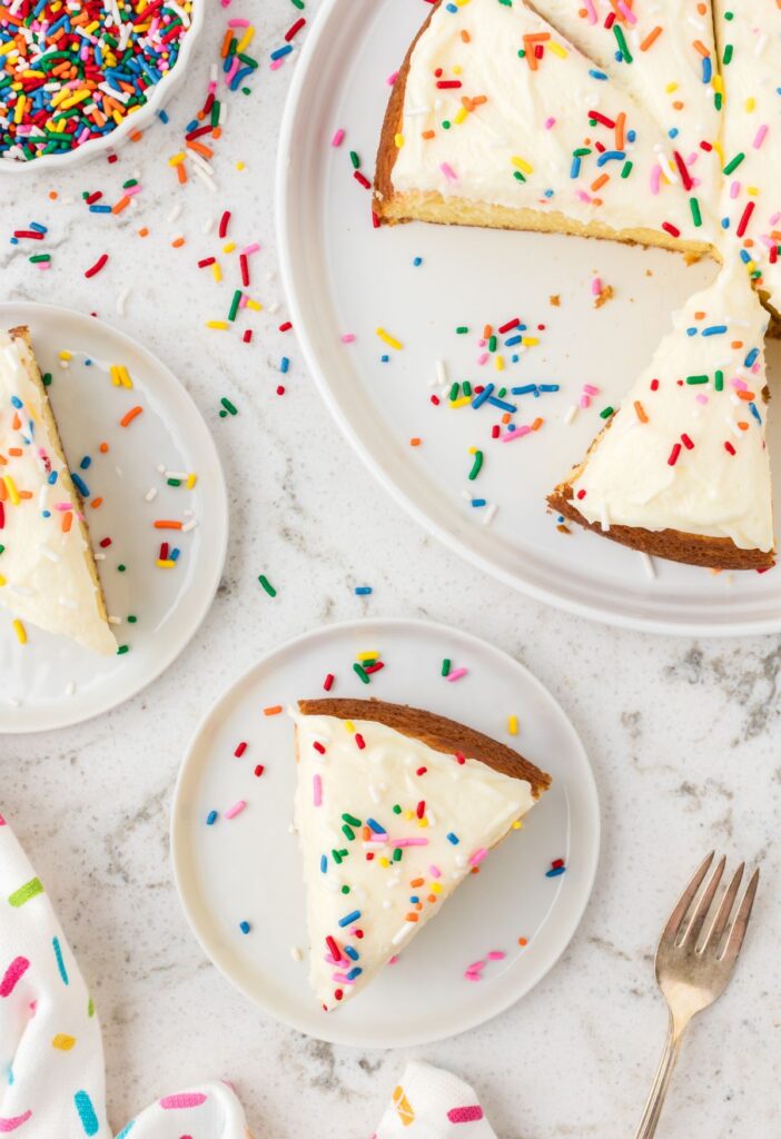Top view of a round cake with a cake mix hack, and a slice of the cake on a plate with a fork.