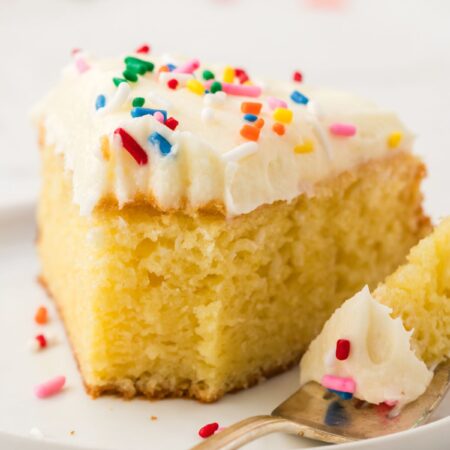 a slice of doctored up cake with frosting and sprinkles.