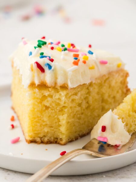 a slice of doctored up cake with frosting and sprinkles.