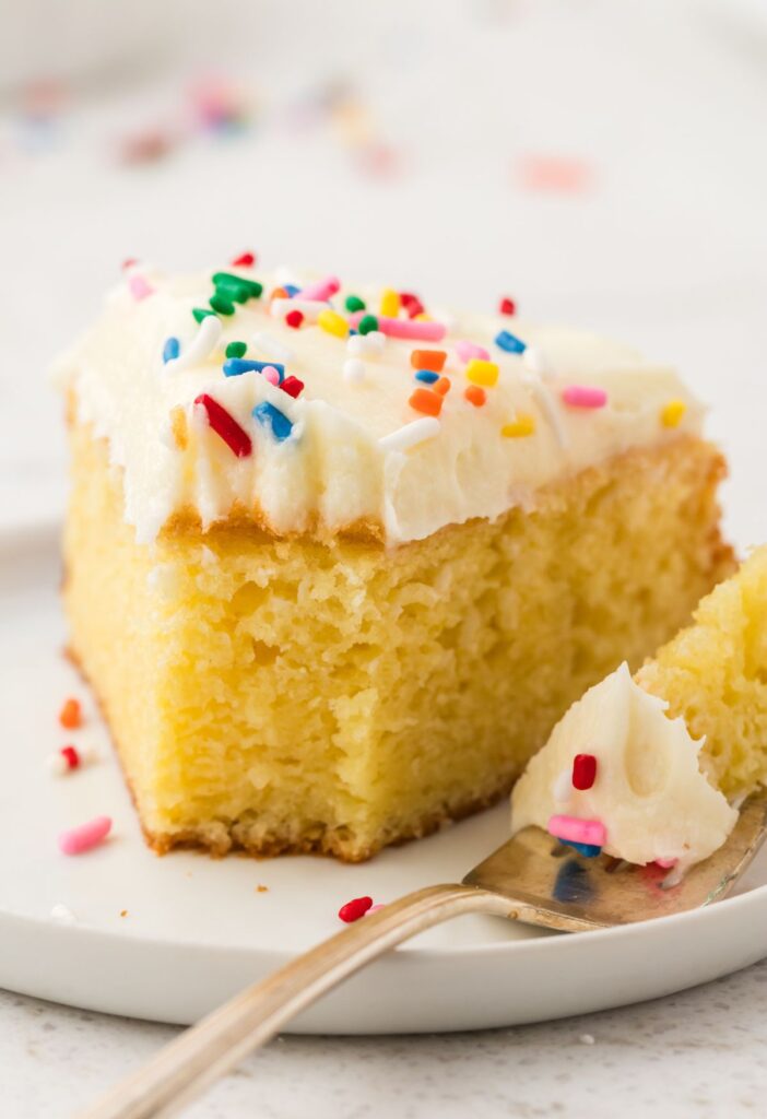 a slice of doctored up cake with frosting and sprinkles.