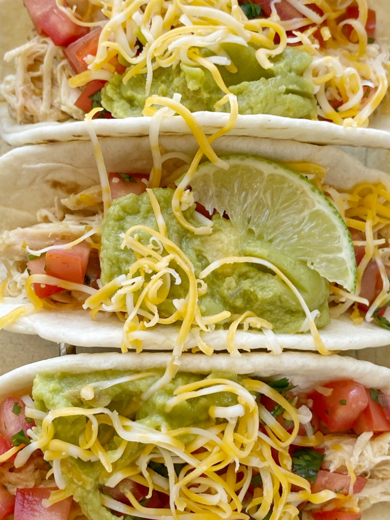Honey Lime Salsa Verde Chicken Tacos cook in the slow cooker with only 6 ingredients! Fresh lime, salsa verde, honey, sour cream, and ranch seasoning make the best chicken tacos ever.