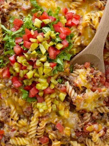 Cheeseburger Casserole is full of cheeseburger favorites like ground beef, onion, garlic, diced tomatoes, spiral pasta, mustard, seasonings, and lots of cheese. Different from traditional creamy, canned soup casseroles and it's family friendly!
