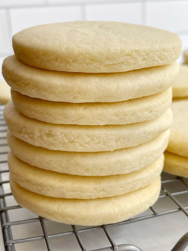 A stack of unfrosted sugar cookies on a cooling rack.