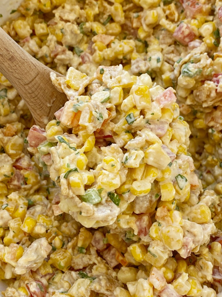 Fritos corn salad with corn, tomatoes, bell peppers, green onion, cilantro, and Fritos in a spiced creamy dressing. This is a salad no one will forget. 
