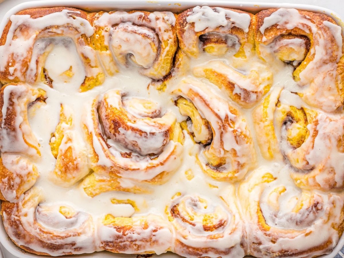 Horizontal photo of cinnamon rolls inside a white pan. 