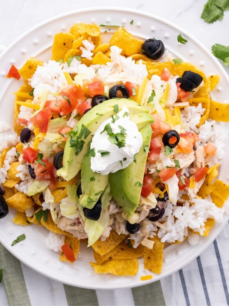 Over head shot of Mexican Haystacks on a white plate with a blue linen beside it. 