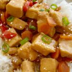 Mongolian Chicken is so easy to make in the slow cooker! Chunks of chicken that fall apart, red pepper, carrots cook in an easy homemade Mongolian inspired sauce. Serve over rice.
