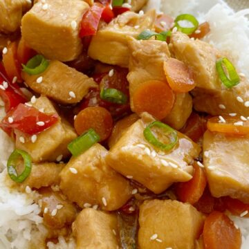 Mongolian Chicken is so easy to make in the slow cooker! Chunks of chicken that fall apart, red pepper, carrots cook in an easy homemade Mongolian inspired sauce. Serve over rice.
