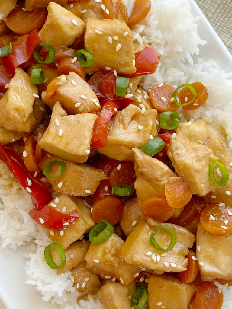 Mongolian Chicken is so easy to make in the slow cooker! Chunks of chicken that fall apart, red pepper, carrots cook in an easy homemade Mongolian inspired sauce. Serve over rice. 