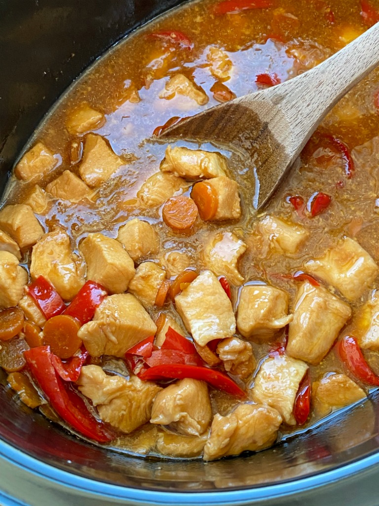 Mongolian Chicken is so easy to make in the slow cooker! Chunks of chicken that fall apart, red pepper, carrots cook in an easy homemade Mongolian inspired sauce. Serve over rice. 