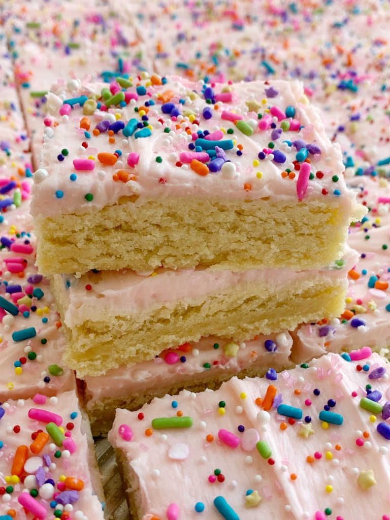 Sugar Cookie Bars | Sugar Cookie Bars are thick, soft-baked and topped with the best cream cheese frosting! Sugar cookie bars bake in a cookie sheet so there is plenty serve a crowd. Change up the frosting color and sprinkles for any event or Holiday.
