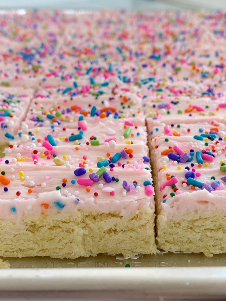 Sugar Cookie Bars | Sugar Cookie Bars are thick, soft-baked and topped with the best cream cheese frosting! Sugar cookie bars bake in a cookie sheet so there is plenty serve a crowd. Change up the frosting color and sprinkles for any event or Holiday.