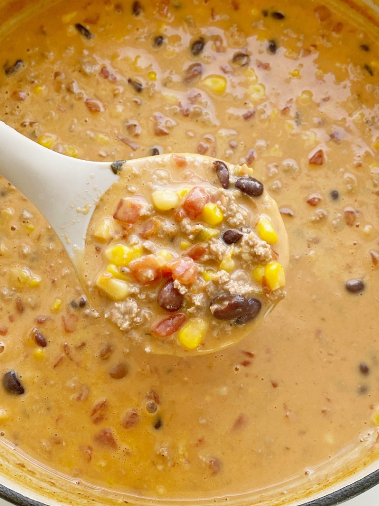 Cheesy Taco Soup is so easy to make in just one pot! Ground turkey, chili beans, black beans, tomatoes, corn, and salsa simmer in chicken broth. Add some Velveeta cheese for the smoothest cheesy taco soup ever.