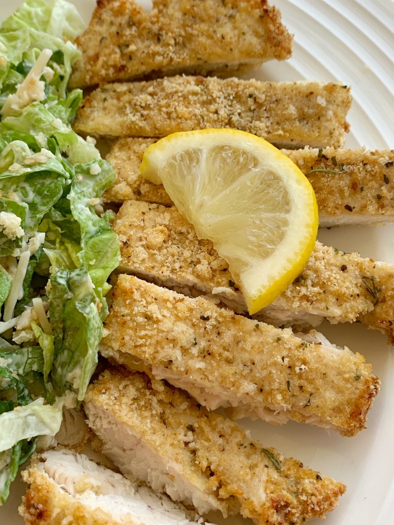 Crispy Baked Lemon Parmesan Chicken | Baked Chicken with a crispy lemon parmesan coating. Boneless skinless chicken breasts, fresh lemon, garlic, Italian breadcrumbs, and parmesan cheese make for the most flavorful crispy baked coating on chicken. It's a family favorite!