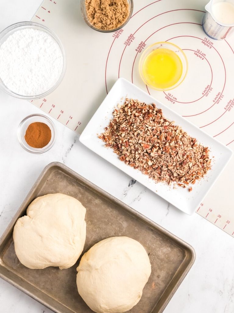 Ingredients needed to make cinnamon rolls overnight with caramel and pecan topping. Ingredients shown in an overhead shot. 