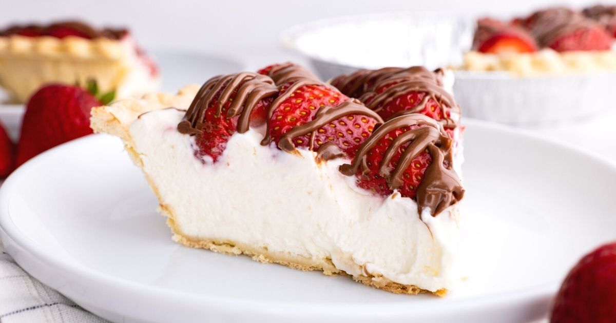 A slice of chocolate strawberry cream pie on a white plate with a fork. 