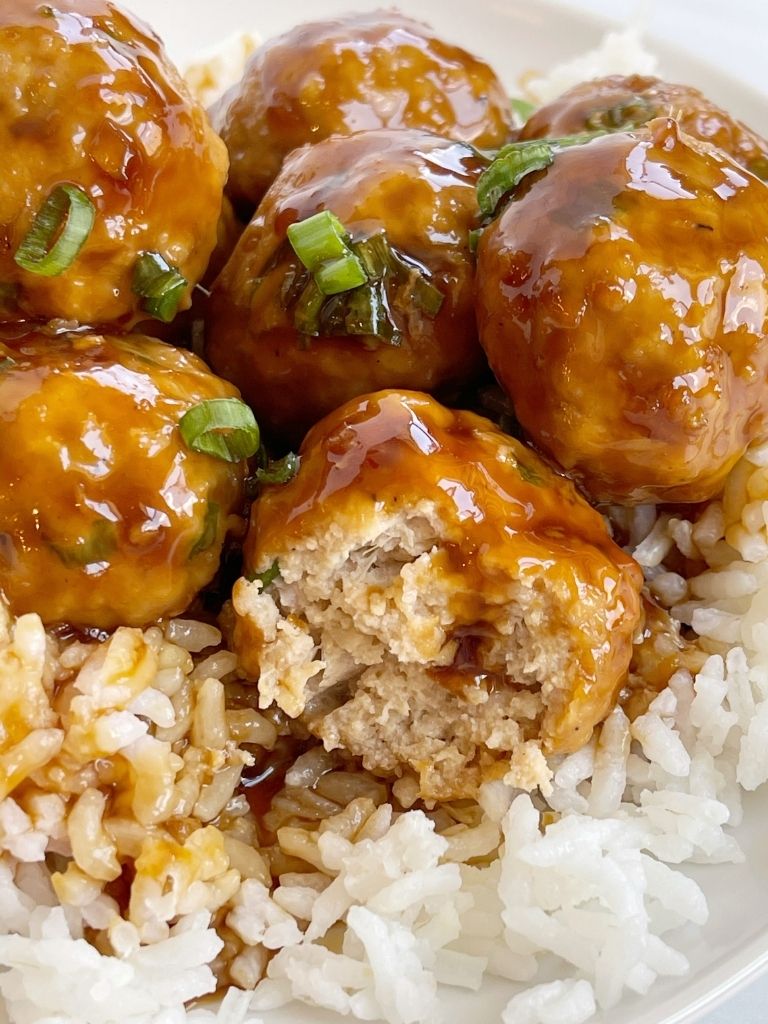 A plate with rice and chicken meatballs on it. 