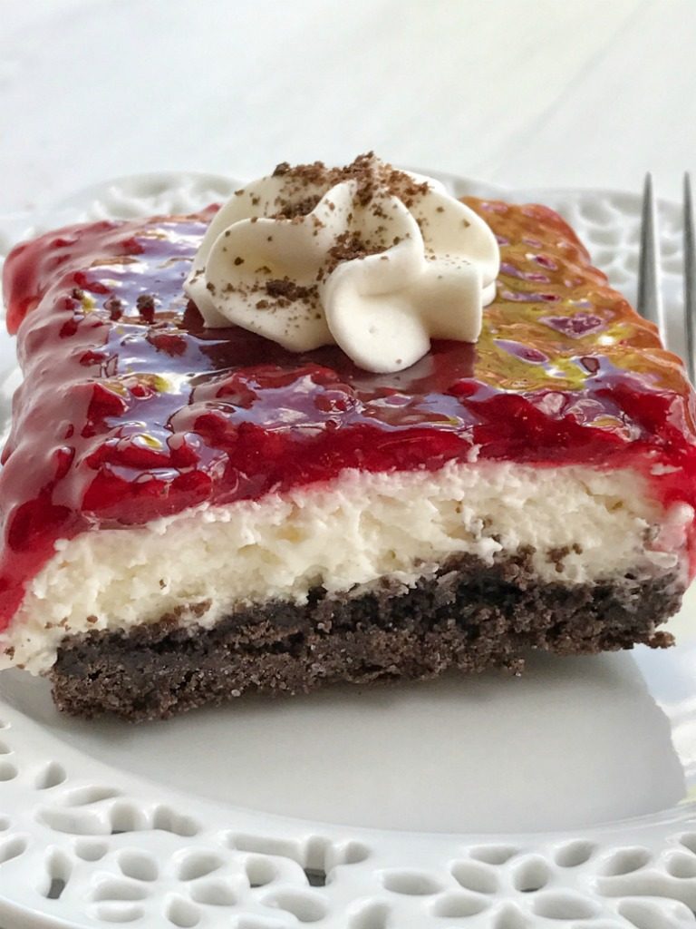 Chocolate raspberry cheesecake delight is an almost no-bake dessert with three delicious layers! A chocolate graham cracker crust, creamy sweet cheesecake middle, and topped with raspberry pie filling. 