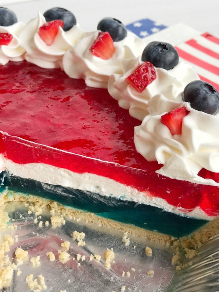 Celebrate the 4th of July with this delicious, totally festive, and easy patriotic Jello pie! 3 layers of red, white, and blue inside a store-bought prepared graham cracker crust. Top with additional Cool Whip and fresh fruit for a show stopper dessert at your own 4th of July picnic.