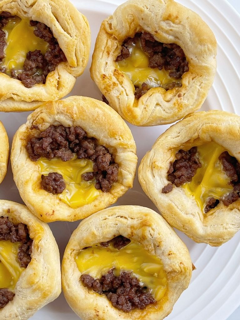 Picture of cheeseburger biscuit cups sitting on a white plate.