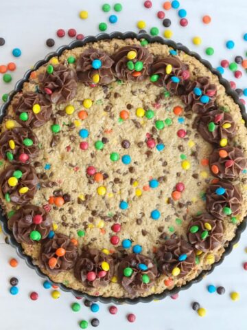A giant monster cookie that's so thick, soft-baked, chewy, and loaded with all the monster cookie favorites. Oats, chocolate, peanut butter, and m&m's. This giant monster cookie makes for a great first day of school tradition too. Kids will love it as a fun after school snack to celebrate their first day. 