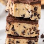 Stack of squares of cookie dough bars with the top piece having a bite taken out of the corner.
