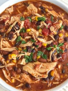You'll love this taco ranch chicken chili that cooks in the slow cooker all day! Tender chicken loaded with vegetables, beans, and plenty of flavor. Only a few pantry staple ingredients is all you need for a satisfying dinner that is so comforting. Be sure and load it up with all your favorite toppings | Together as Family Blog | recipe | chili | taco soup | slow cooker | crock pot