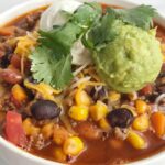Taco chili with a twist! This veggie loaded taco chili is the best of two favorite soups. Loaded with vegetables, beans, seasoned ground beef and simmered in a flavorful broth. Healthy, delicious, warm & comforting, and sure to be a hit.