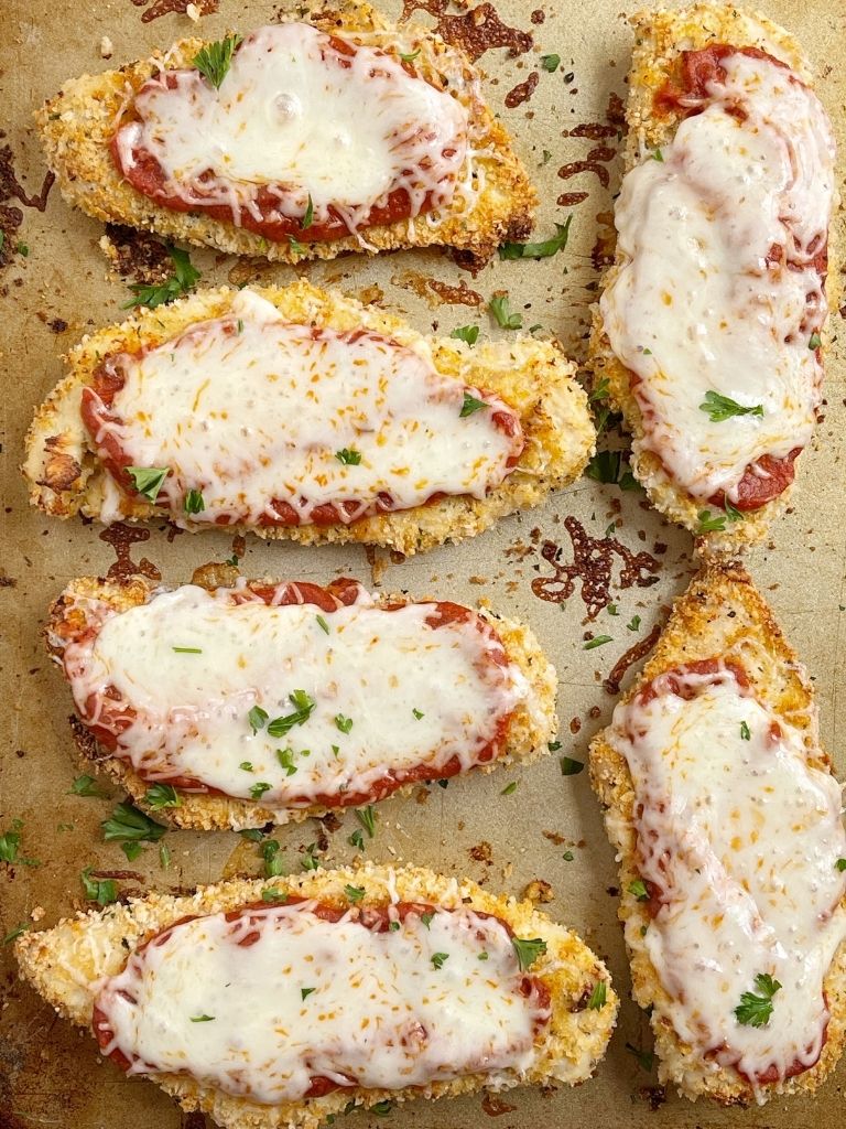 A tray of chicken parmesan with marinara sauce and cheese.