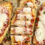 Baking sheet with parmesan chicken and cheese.