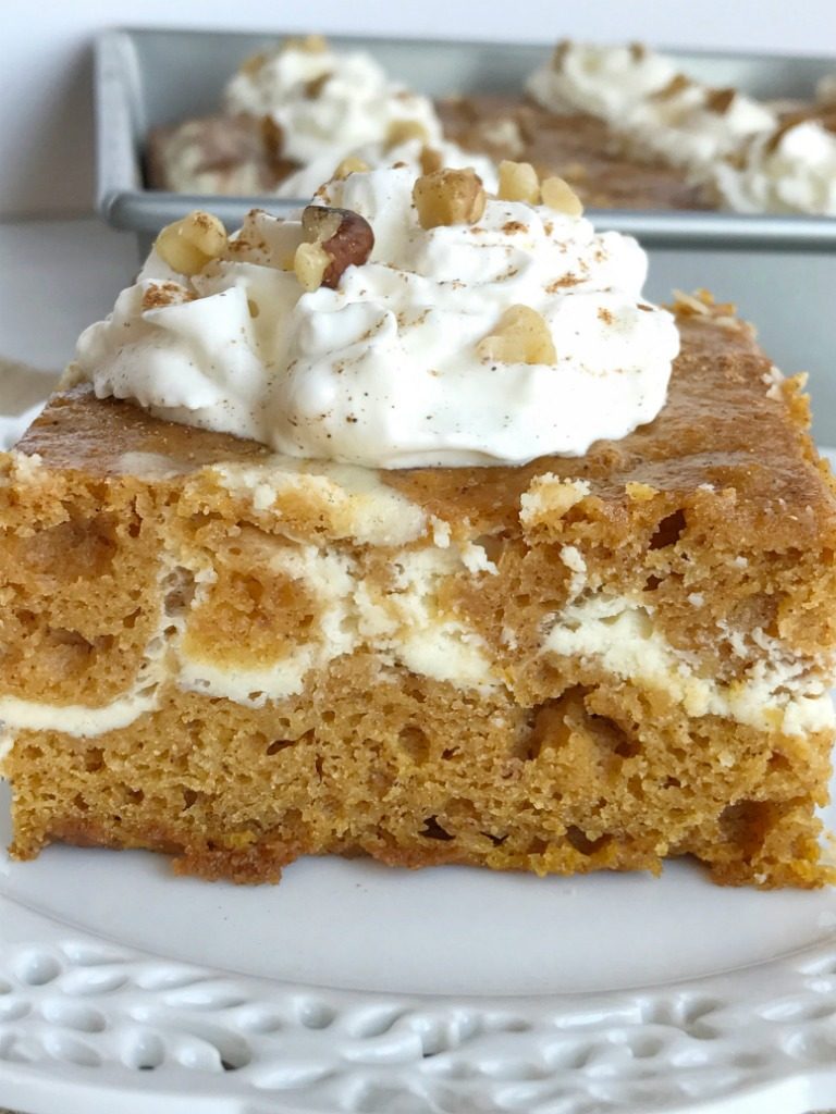 Cheesecake swirl pumpkin cake is a moist and flavorful pumpkin cake loaded with warm pumpkin spices and has a sweet cheesecake swirl. Garnish with whipped cream and chopped pecans for a delicious pumpkin dessert recipe | www.togetherasfamily.com #pumpkin #pumpkincake #dessert #recipe