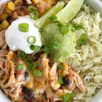 Slow cooker chicken taco burrito bowls are a fuss-free, minimal prep & ingredients, and a family favorite dinner recipe. Cheesy chicken taco meat is made in the slow cooker! Create your very own burrito bowl, at a fraction of the cost of take-out, right at home. Cheesy chicken taco meat served over some cilantro lime rice and topped with avocado, sour cream, green onions, and whatever else you want | www.togetherasfamily.com #chickenrecipes #tacorecipes #tacos #slowcookerrecipes #crockpotrecipes #burritobowls