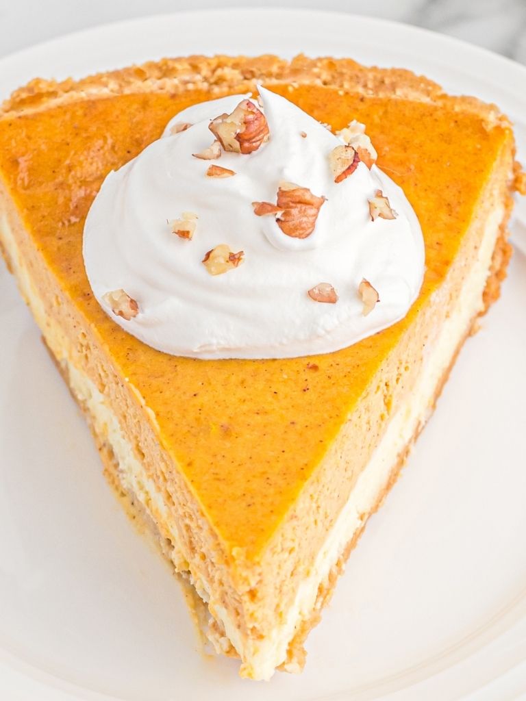 Slice of pumpkin cheesecake on a white plate.