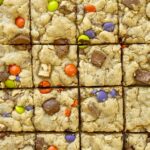 Leftover Halloween Cookie Bars are the best way to use up all that Halloween candy! Soft-baked, thick, chewy, peanut butter oatmeal cookie bars loaded with 2 cups of chopped candy. Kids will love to pick out the candy to put in these bars.