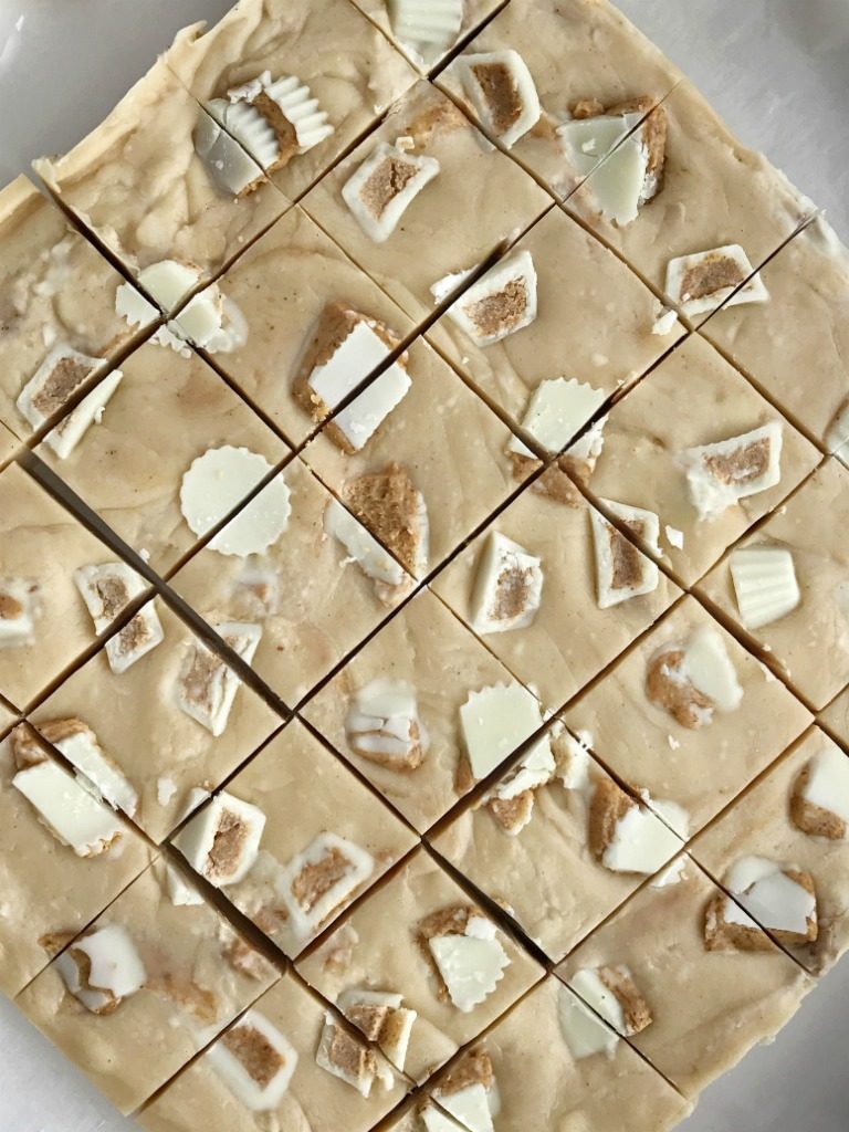 White Chocolate Peanut Butter Reese's Fudge | 4 Ingredients is all you need for this deliciously creamy easy white chocolate peanut butter fudge that's loaded with Reese's! Simple ingredients and only 5 minutes of cook time. It's the perfect treat for Christmas cookie plates. You won't believe how silky smooth this fudge is | www.togetherasfamily.com #fudgerecipes #peanutbutterfudge #christmascookies #reesesrecipes #reesesfudge #whitechocolatefudge #whitechocolatefudge #easyfudgerecipe